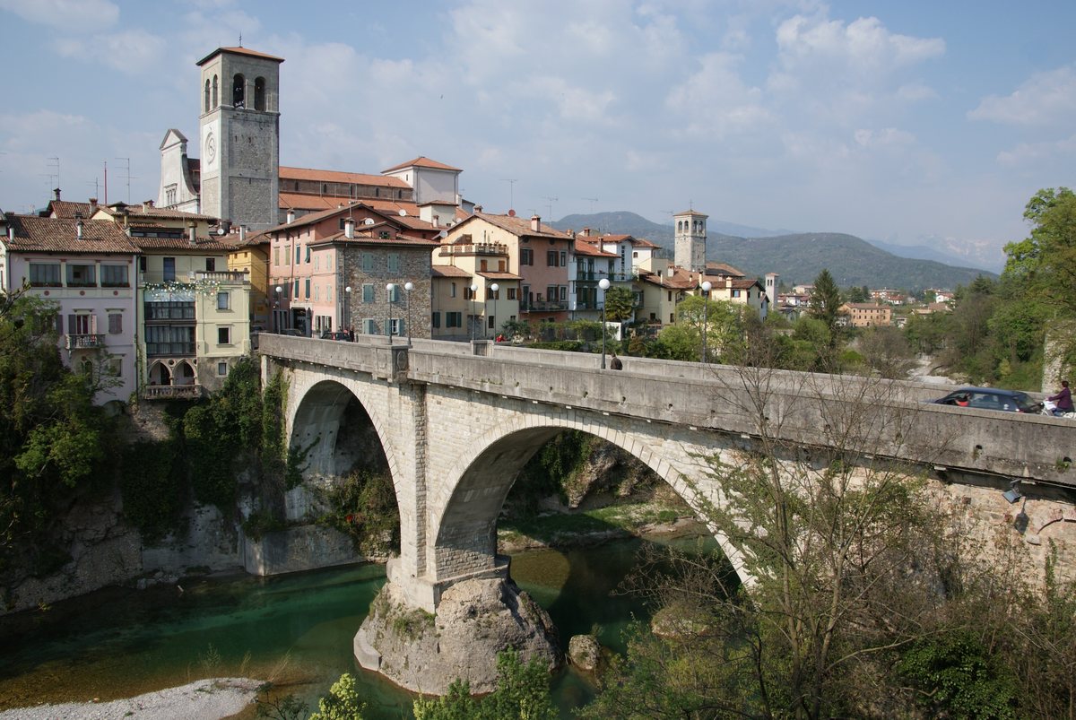 The stone Devil's Bridge over the Natisone river, with the old town and cathedral bell tower of Cividale behind.