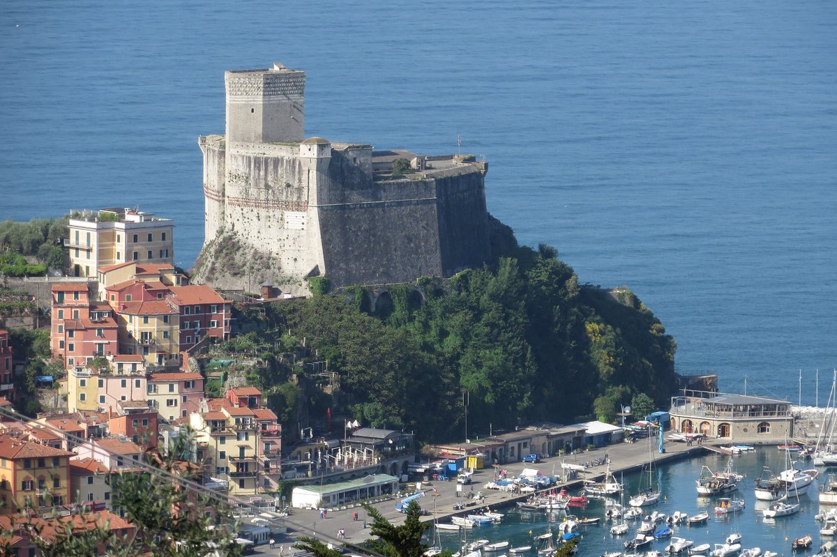 The castle of Lerici on its headland above the harbour and pastel houses, with the sea beyond.