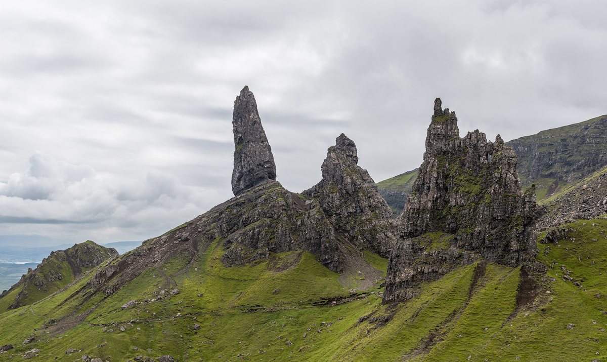 The rock pinnacles of the Old Man of Storr rising above green slopes on the Isle of Skye.