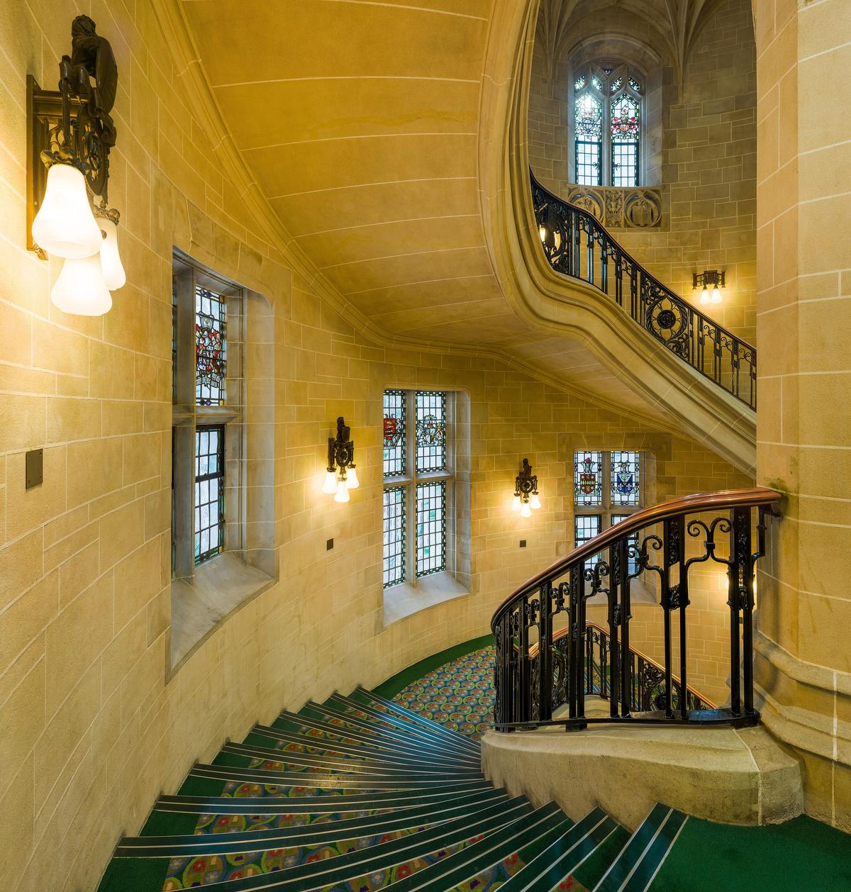 A curving stone staircase with a wrought-iron balustrade inside the Supreme Court building in London.